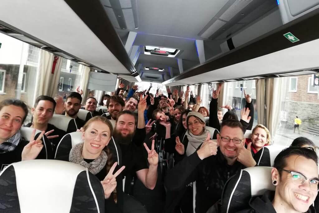 Gruppe von Personen sitzt im Bus und macht ein Gruppenfoto.