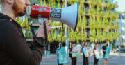 PETA Streetteam Demonstration auf der Strasse. Mann mit Megafon in der Hand.