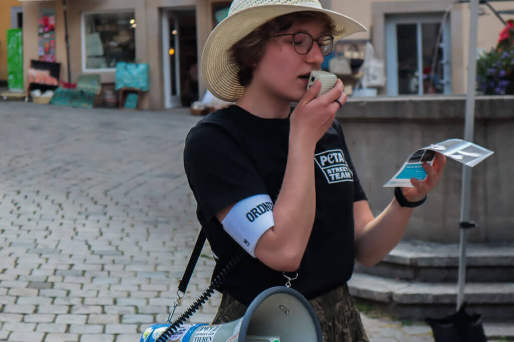 PETA Streetteam Demo. Frau mit Megafon.