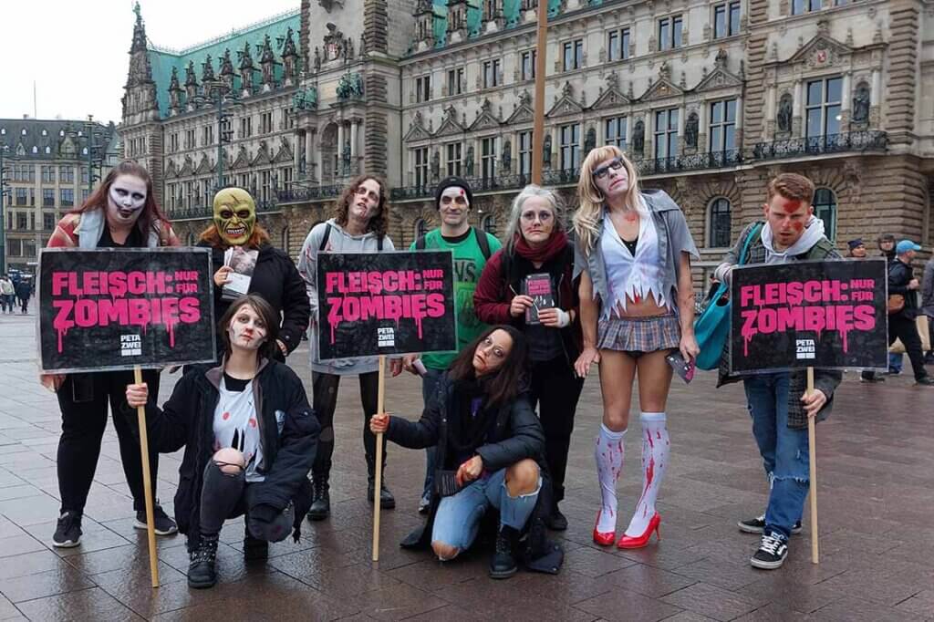 Menschen in Kostümen halten Schilder