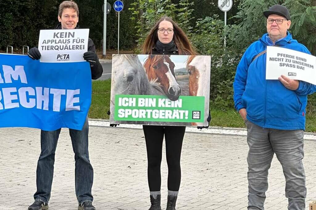 Menschen in Kostümen halten Schilder