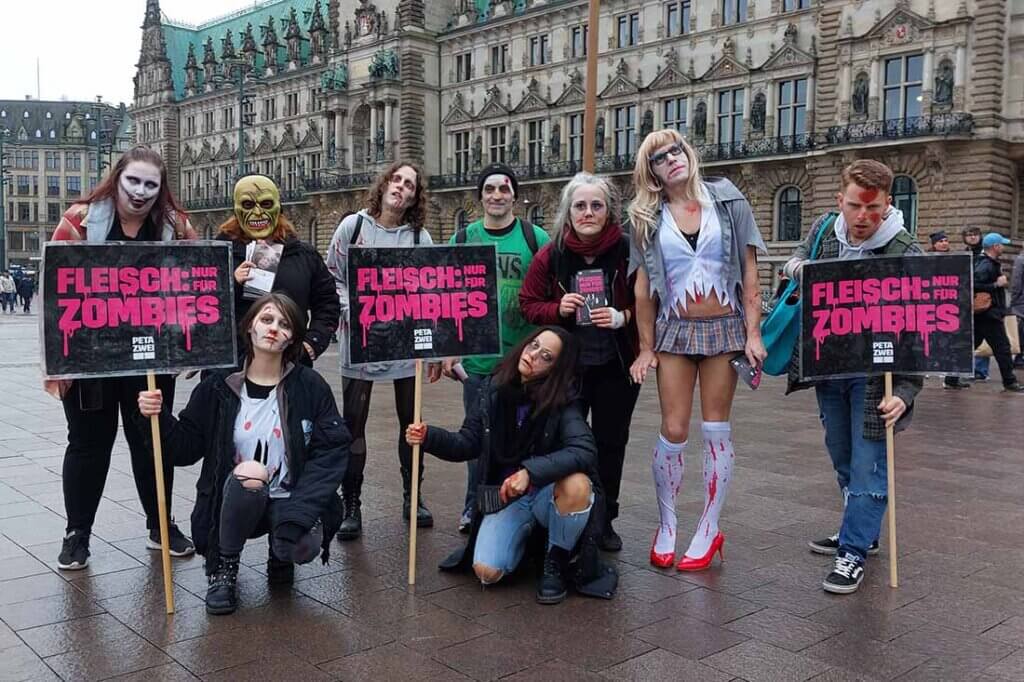 Menschen stehen zusammen in Zombie Kostümen