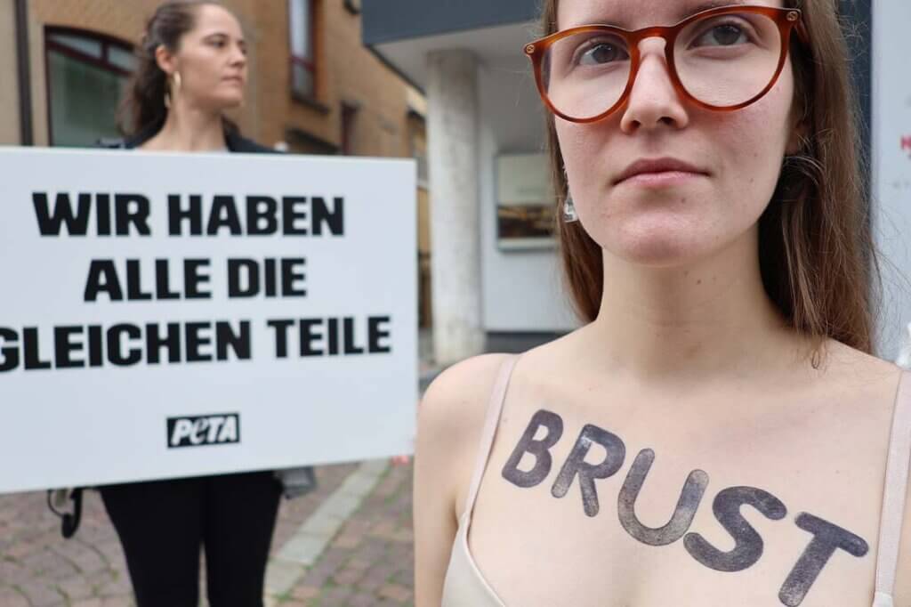 Demonstrantin mit Stempelaufdruck auf der Brust.